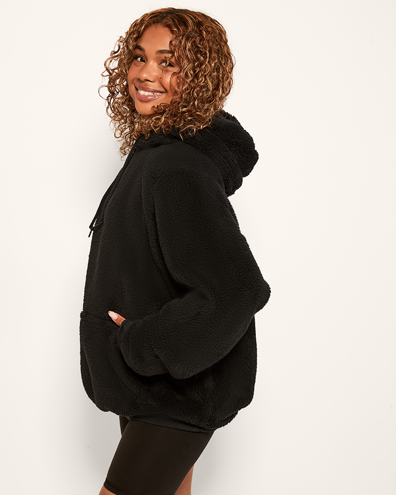 Person wearing a black hoodie on a white background