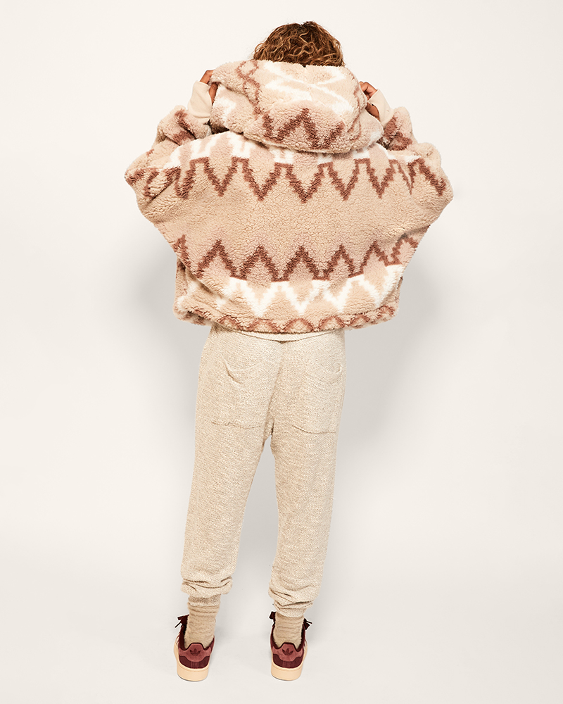 Person wearing a patterned jacket and pants on a white background