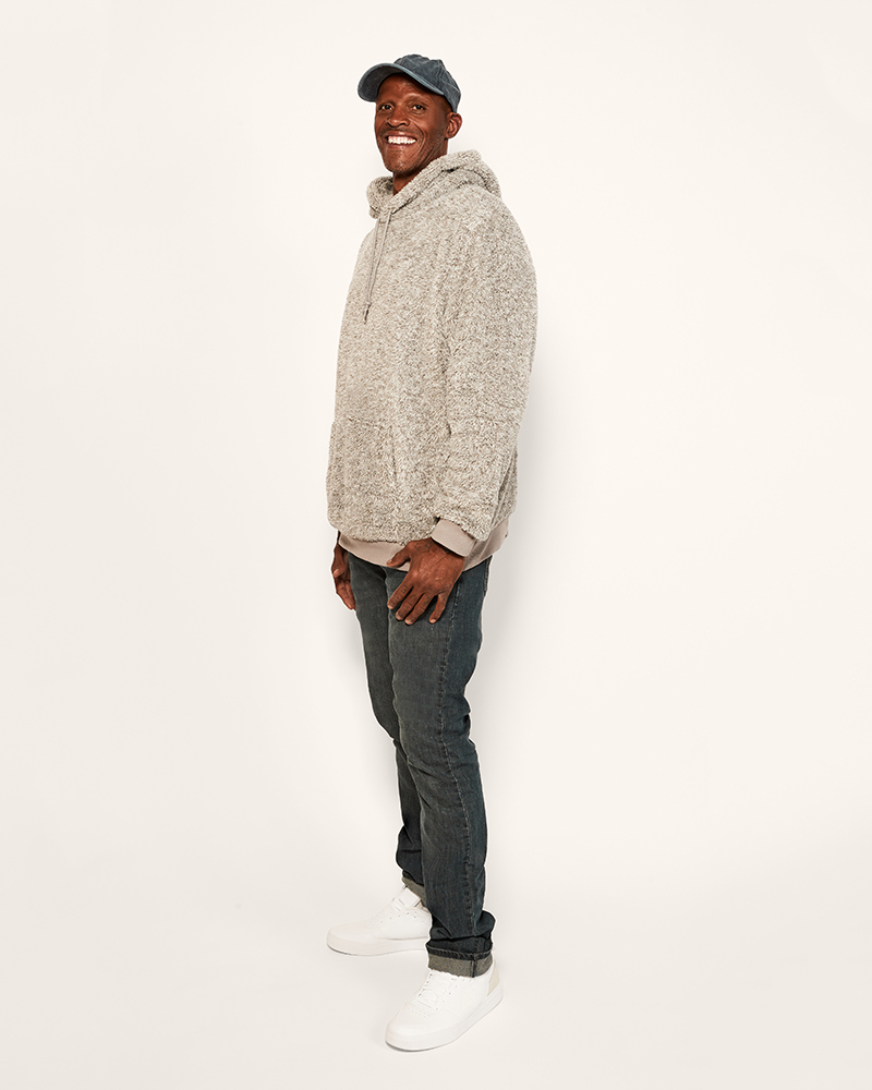 Man wearing a gray hoodie and jeans on a white background