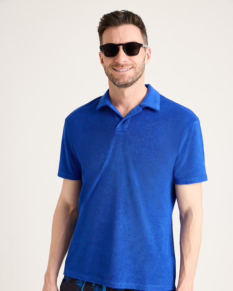 Man wearing a blue polo shirt and sunglasses on a plain background|Model: 5'11" wearing size L