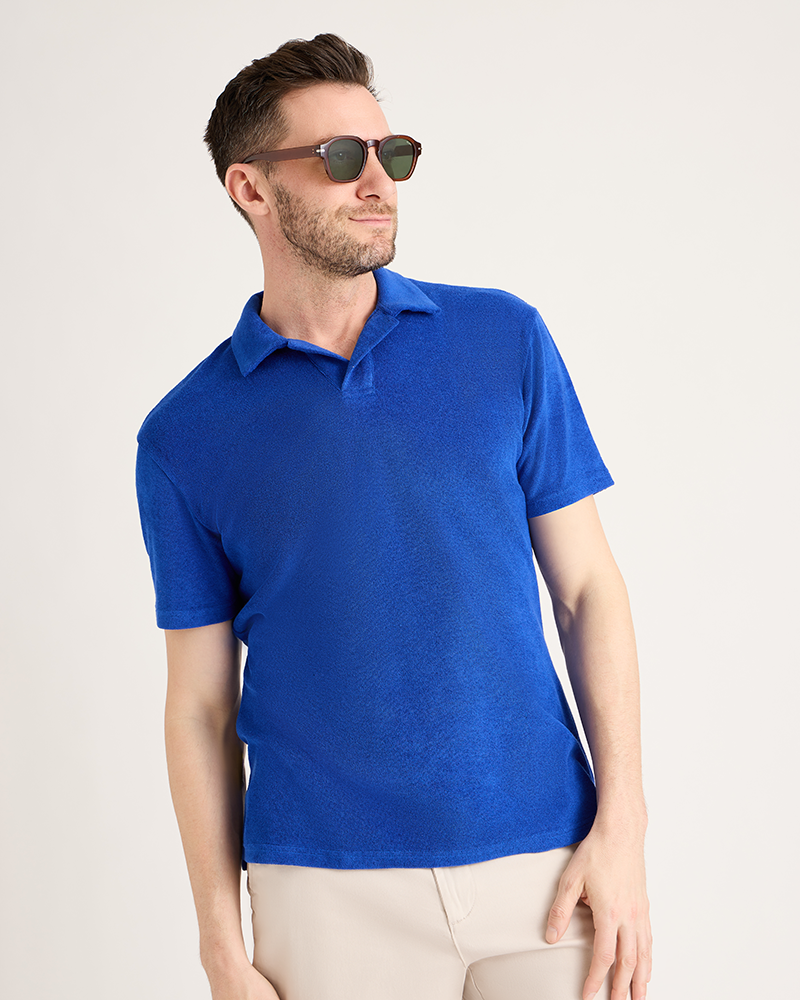Man wearing a blue polo shirt and sunglasses on a light gray background|Model: 5'11" wearing size L