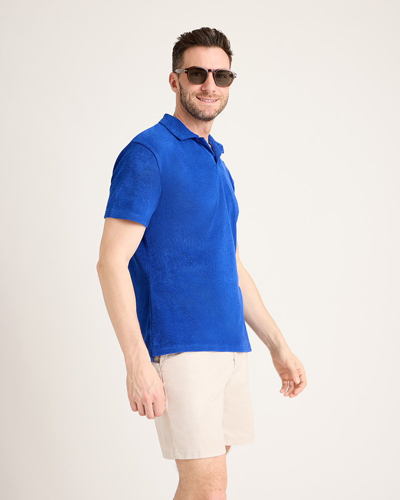 Man wearing a blue polo shirt and beige shorts on a white background|Model: 5'11" wearing size L