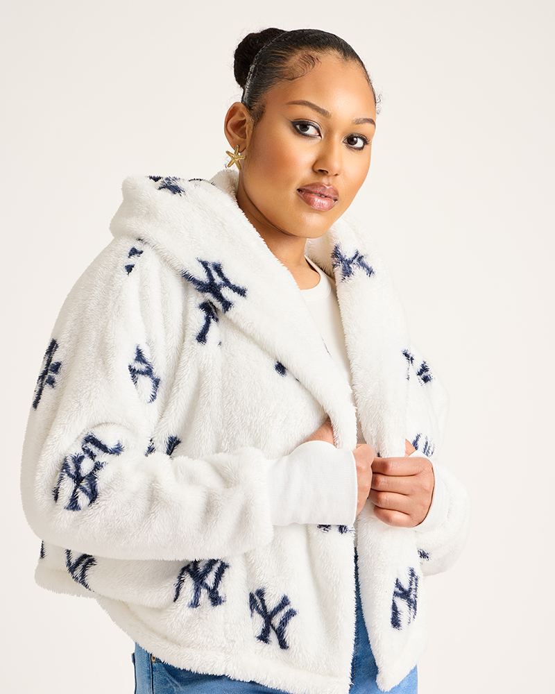 Woman wearing a white fleece jacket with blue patterns on a plain background|Model: 5'9" in size XS/S