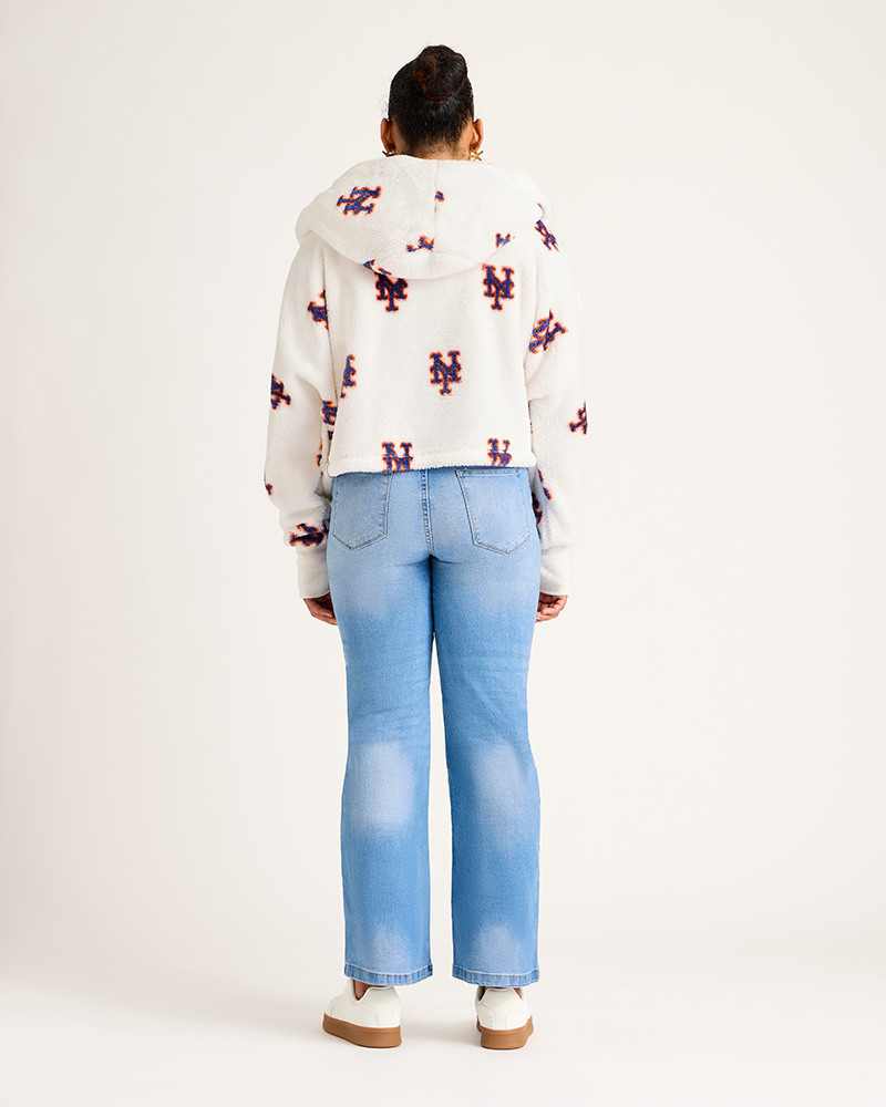 Person wearing a patterned jacket and light blue jeans on a white background|Model: 5'9" in size XS/S