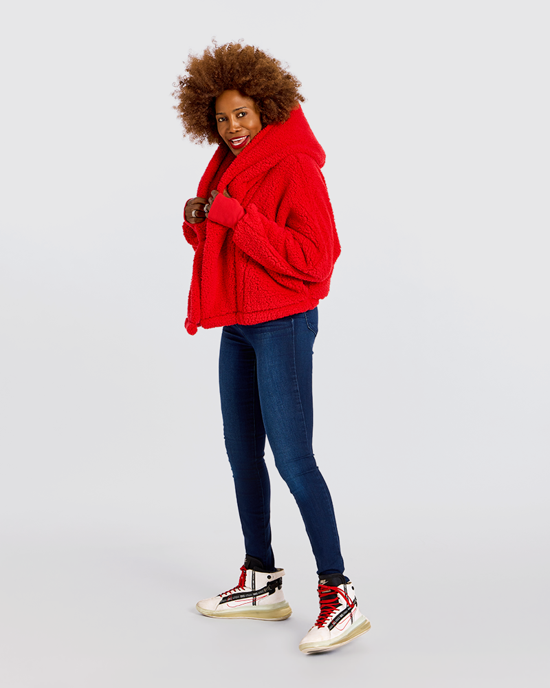 A woman modeling a bright red textured hooded jacket, paired with dark blue skinny jeans and white high-top sneakers with red and black details, against a solid light gray background.|Model is 5'7" wearing size XS/S