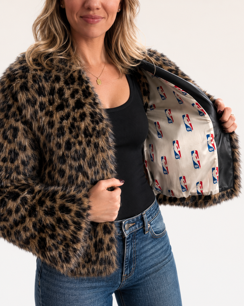 Person wearing a leopard print coat with NBA logo lining, on a white background