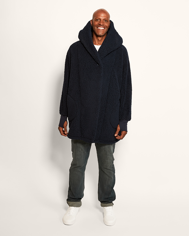 Man wearing a dark blue hooded coat on a white background