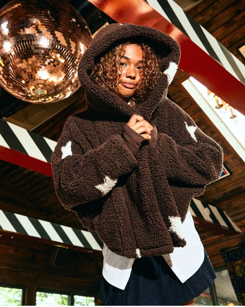 girl wearing brown with white stars cropped lounger with disco ball in background