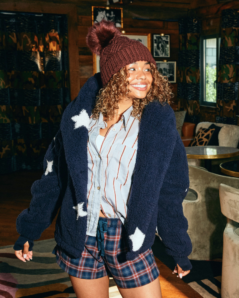 girl wearing navy star lounger with hat and boxer shorts in a cabin