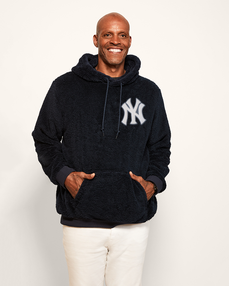 man wearing navy hoodie with chenille yankees logo in upper left corner