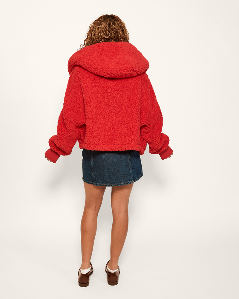 Person wearing a red fleece jacket on a white background