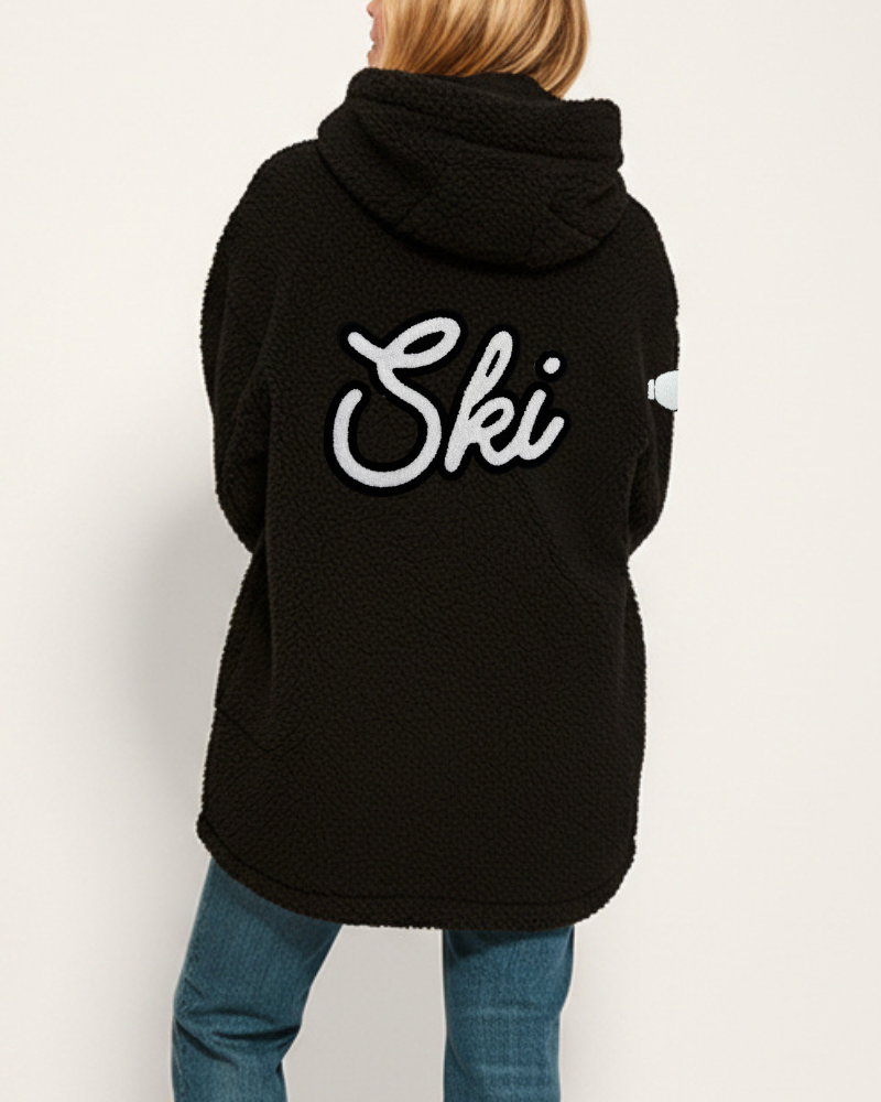 Black hoodie with 'Ski' text on the back worn by a person, against a plain background