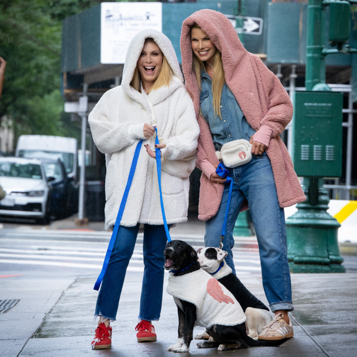 people wearing sherpa loungers that are pink and white walking dogs with sherpa pet jackets
